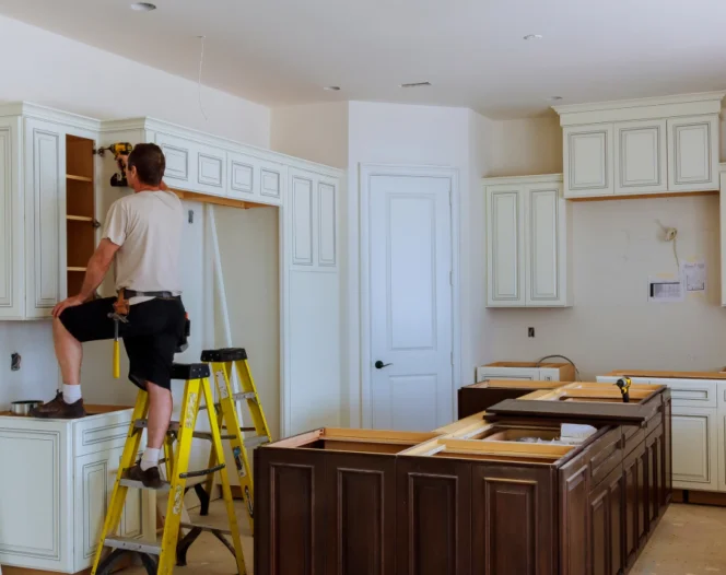 man installing new cabinets